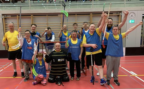 Die Gruppe trägt blaue Tricots